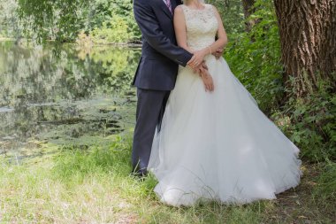 Gelin ve damat stand bahçede sarılma.