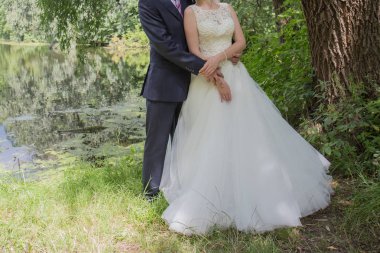 Gelin ve damat stand bahçede sarılma.