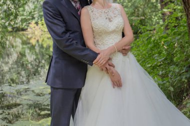 Gelin ve damat stand bahçede sarılma.