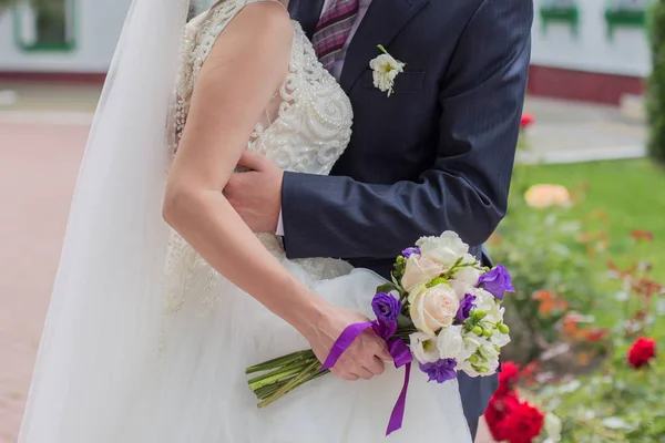 Braut und Bräutigam halten Händchen im Park — Stockfoto