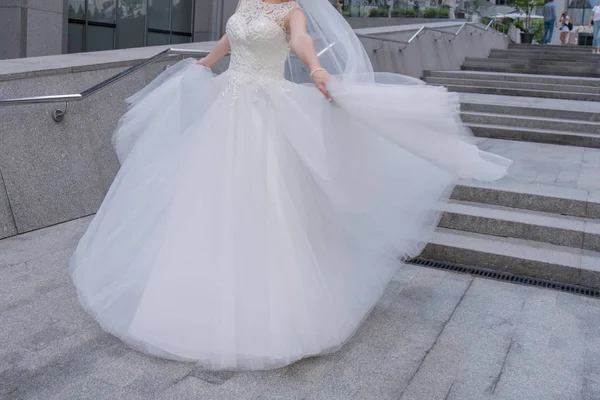 Die Braut im Brautkleid wirbelt auf der Treppe — Stockfoto