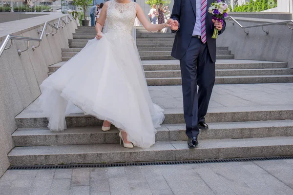 Bruden och brudgummen gå ner för trapporna — Stockfoto