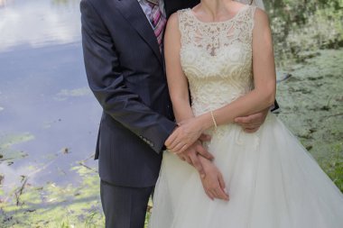 Gelin ve damat stand bahçede sarılma.