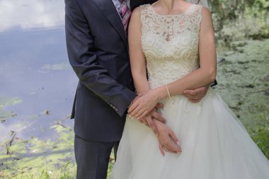 Gelin ve damat stand bahçede sarılma.