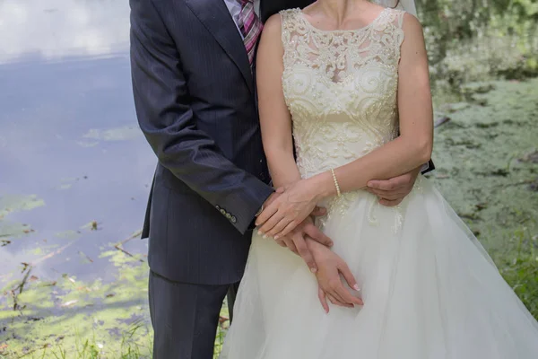 Gelin ve damat stand bahçede sarılma.