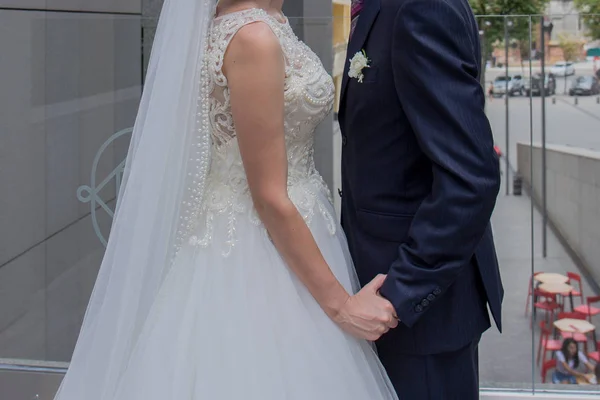 Bruid en bruidegom staan samen in de buurt van het gebouw — Stockfoto