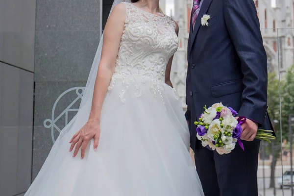 Невеста и жених стоят рядом со зданием — стоковое фото