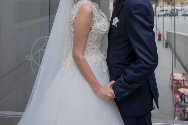 Braut und Bräutigam stehen in der Nähe des Gebäudes zusammen — Stockfoto