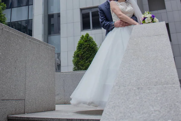 Noiva e noivo estão de pé perto das escadas — Fotografia de Stock