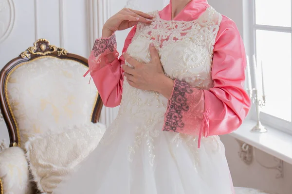 バスローブ姿で近く彼女のウェディング ドレスの花嫁 — ストック写真