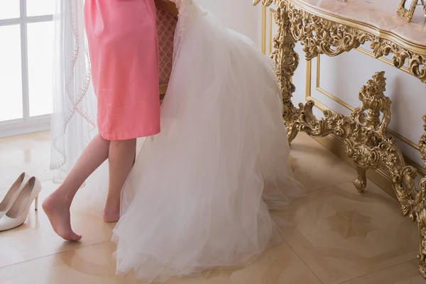 Panna Młoda w szlafroku w pobliżu jej suknia ślubna — Zdjęcie stockowe