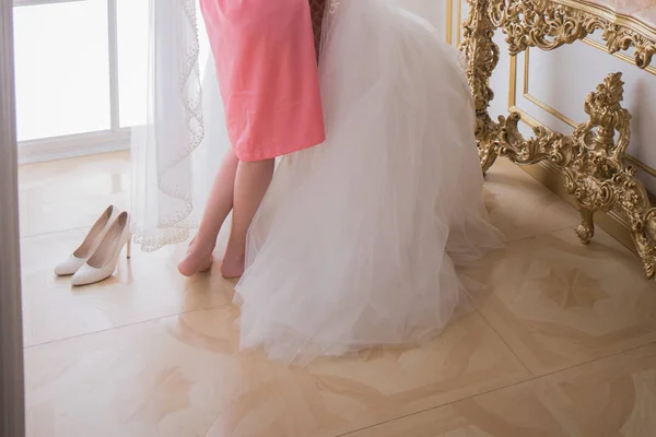 Noiva em um roupão de banho perto de seu vestido de noiva — Fotografia de Stock