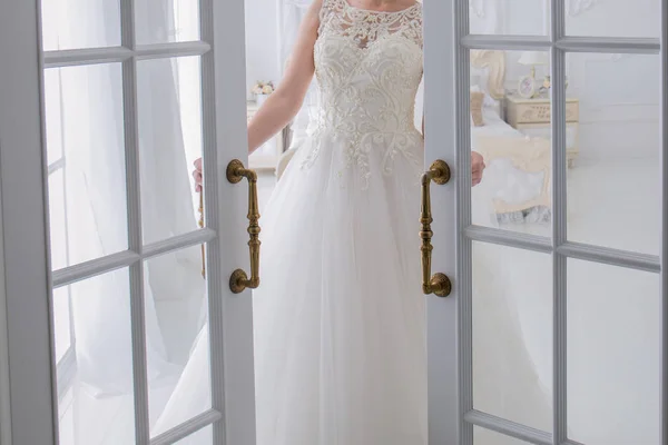 Panna Młoda w sukni ślubnej stoi obok drzwi — Zdjęcie stockowe