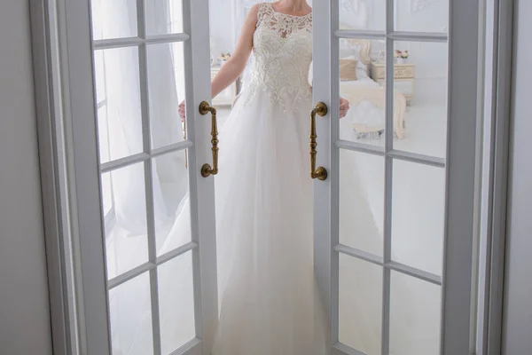 Nevěsta ve svatebních šatech stojí u dveří — Stock fotografie