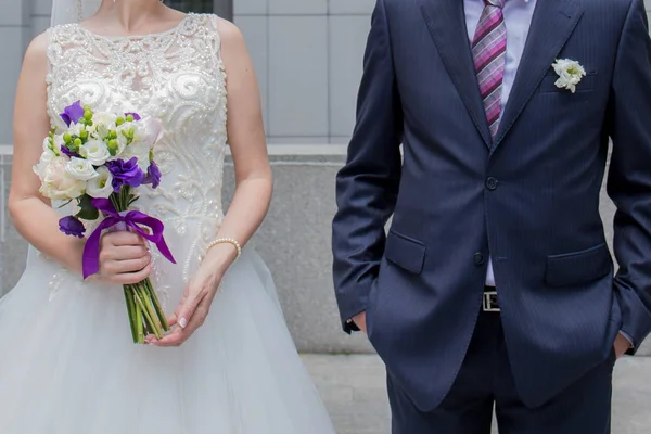 Newlyweds stand together near building in city — Stock Photo, Image