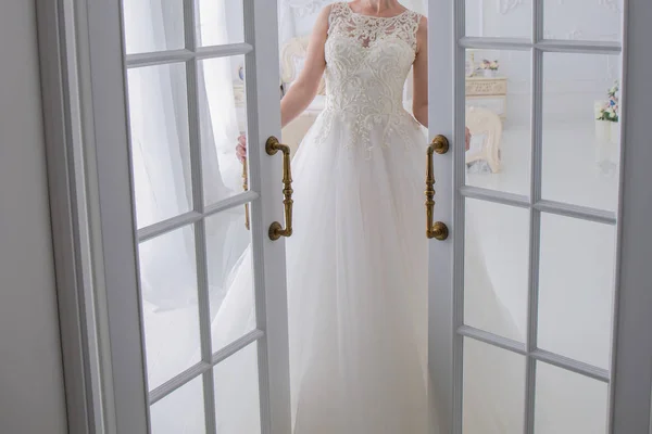Nevěsta ve svatebních šatech stojí u dveří — Stock fotografie