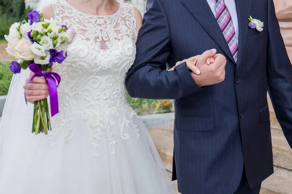 Newlyweds stand together near building in city — Stock Photo, Image