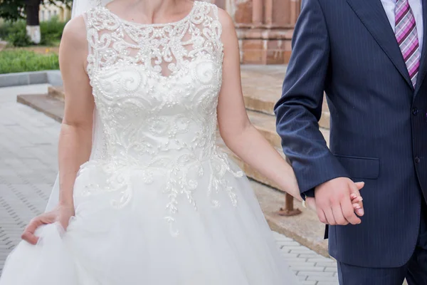 Newlyweds stand together near building in city — Stock Photo, Image