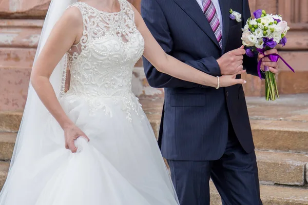 Newlyweds stand together near building in city — Stock Photo, Image