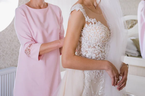 Noiva colocar um vestido de noiva no quarto — Fotografia de Stock