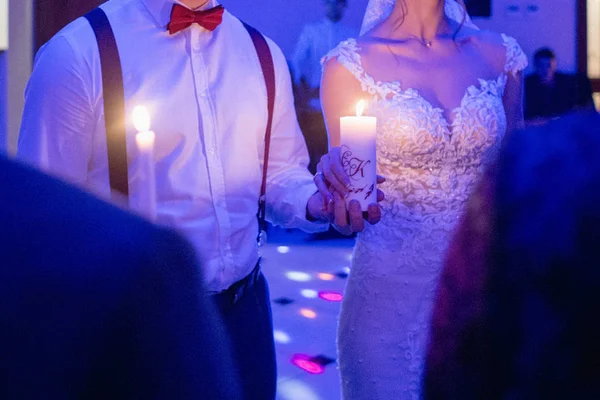 Novia y novio sostienen velas en sus manos — Foto de Stock