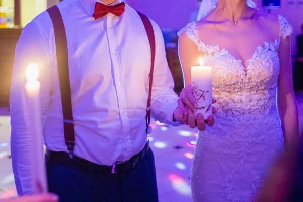 Bruid en bruidegom houden kaarsen in hun handen — Stockfoto