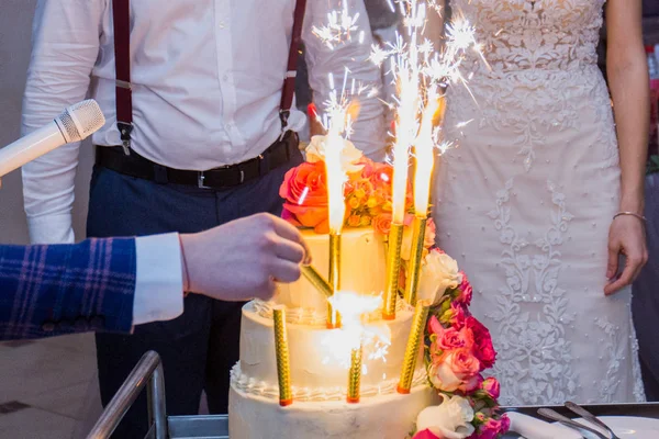 Fogos de artifício em um bolo de casamento no fundo dos recém-casados — Fotografia de Stock