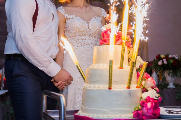 Феєрверки на весільному торті на фоні молодят — стокове фото