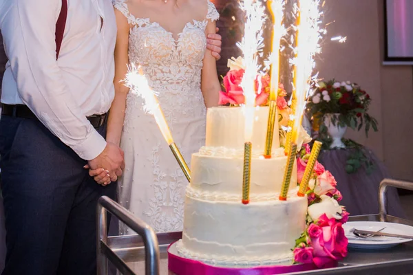 Tűzijátékok a háttérben, az ifjú egy esküvői torta — Stock Fotó