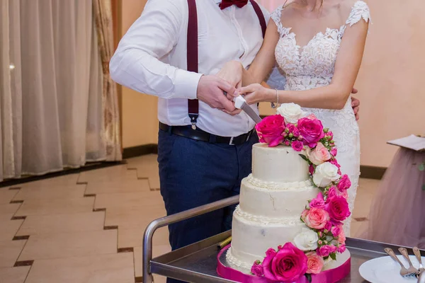 Novia y novio cortan el pastel de bodas juntos — Foto de Stock