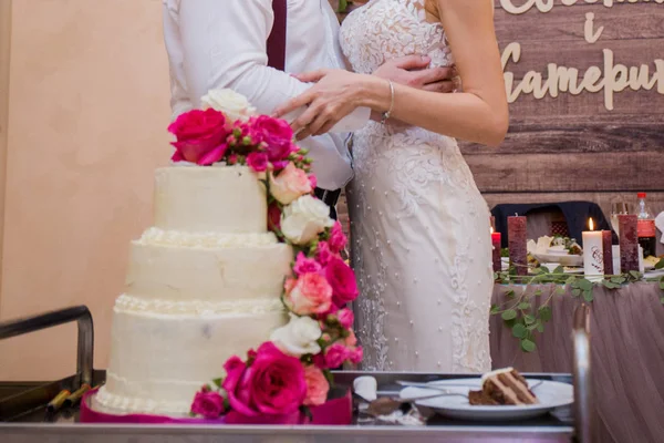 Bruden och brudgummen skär bröllopstårta tillsammans — Stockfoto