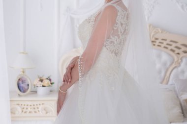 gelin düğün buket aydınlık bir salonda tutar.