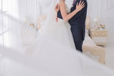 Gelin ve damat birlikte aydınlık bir salonda stand