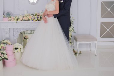 Gelin ve damat birlikte aydınlık bir salonda stand