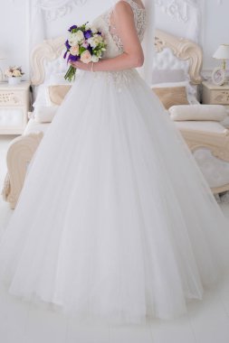 gelin düğün buket aydınlık bir salonda tutar.