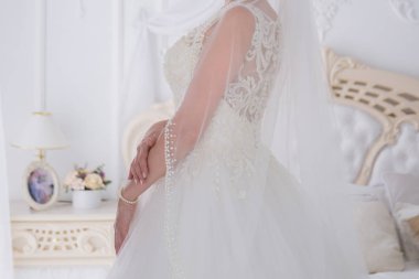 gelin düğün buket aydınlık bir salonda tutar.