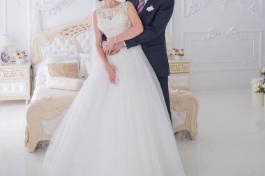 Gelin ve damat birlikte aydınlık bir salonda stand