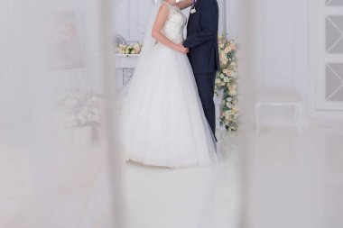 Gelin ve damat birlikte aydınlık bir salonda stand