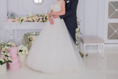 Gelin ve damat birlikte aydınlık bir salonda stand