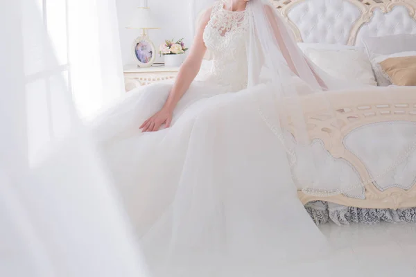 Nevěsta ve svatebních šatech v jasné místnosti — Stock fotografie