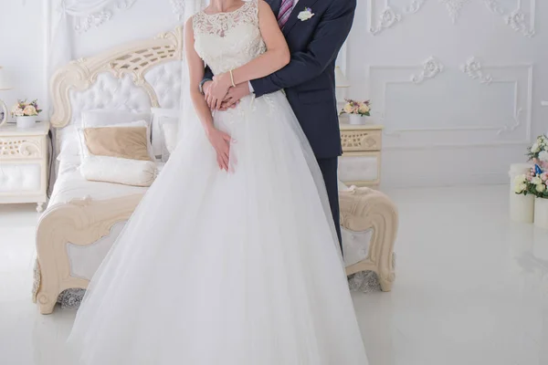 Невеста и жених стоят вместе в светлой комнате — стоковое фото