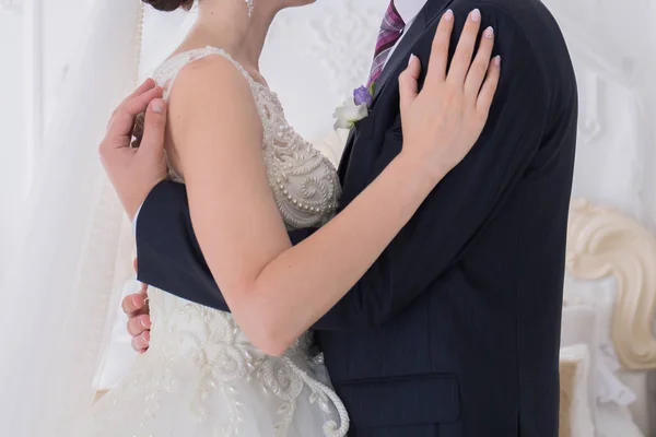 Bruden och brudgummen står tillsammans i ett ljust rum — Stockfoto