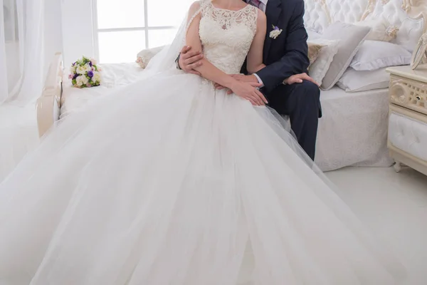 Bride and groom sit together on the bed — Stock Photo, Image