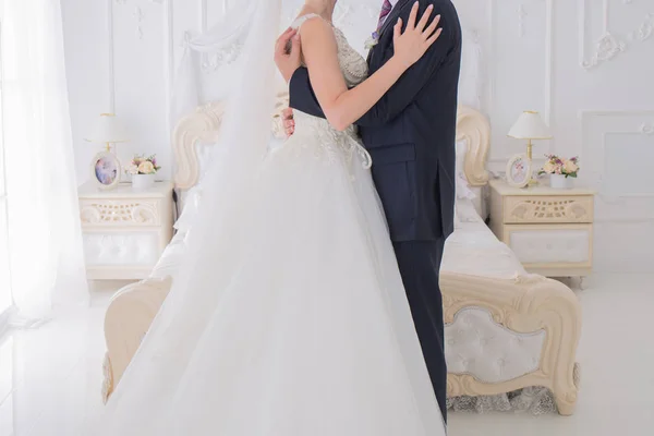 Bride and groom stand together in a bright room — Stock Photo, Image