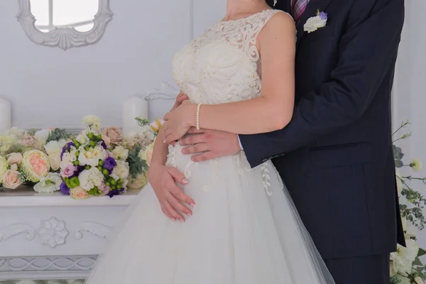 Невеста и жених стоят вместе в светлой комнате — стоковое фото