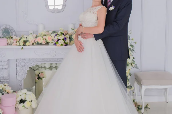 Bride and groom stand together in a bright room — Stock Photo, Image