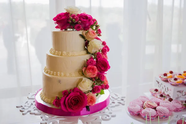 Wedding cake near the candy bar on the table — Stock Photo, Image