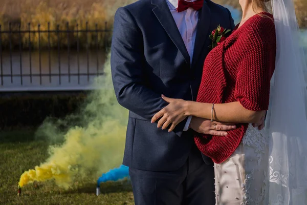 Fumaça colorida atrás dos recém-casados no parque — Fotografia de Stock