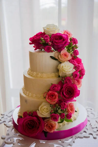 Свадебный торт рядом с шоколадкой на столе — стоковое фото