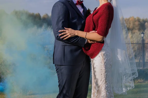 Fumaça colorida atrás dos recém-casados no parque — Fotografia de Stock